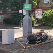 Fly-tipped mess dumped underneath a 'no fly-tipping' sign.