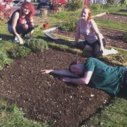 Students ‘take 5’ after clearing a weedy bed ready now for planting flowers, pumpkins and rhubarb.