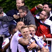 Happy days: Jake Baxter enjoys one of his two goals in Tooting & Mitcham's London Senior Cup win at the end of the season