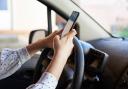 Using mobile phone while driving (stock image via Marco Verch on Flickr)