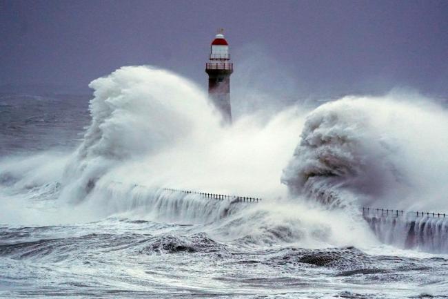 Huge waves crash the against the sea wall and Roker Lighthouse