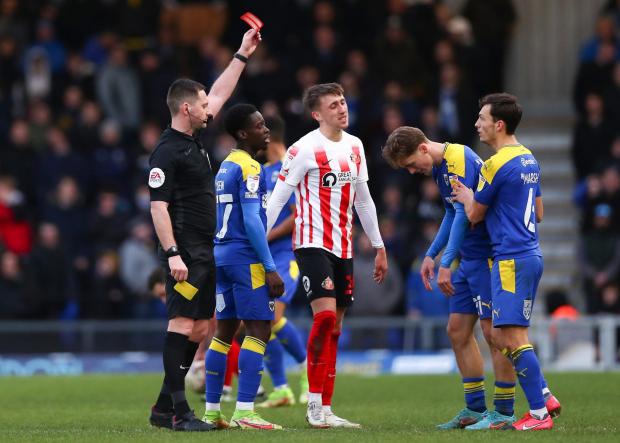Wandsworth Times: AFC Wimbledon's Luke McCormick receives a red card from the referee during the Sky Bet League One match at The Cherry Red Records Stadium, London. 