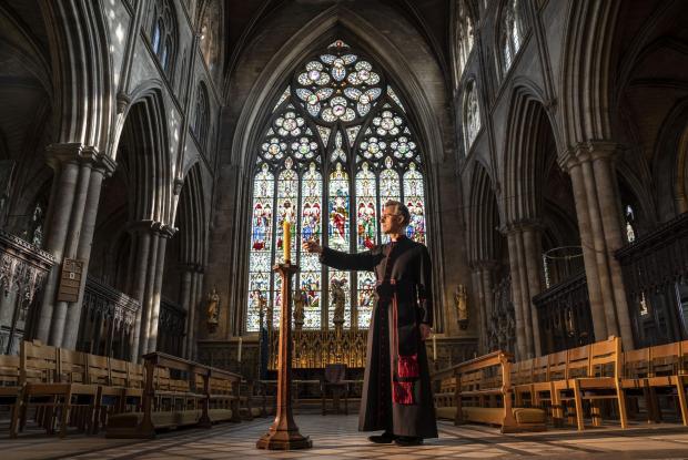 Wandsworth Times: Very Reverend John Dobson Dean of Ripon lights a candle to mark the second anniversary of the first national coronavirus lockdown at Ripon Cathedral, North Yorkshire, ahead of the National Day of Reflection on Wednesday (PA)