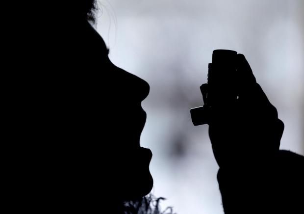 Wandsworth Times: Silhouette of a person using an inhaler. Credit: Canva
