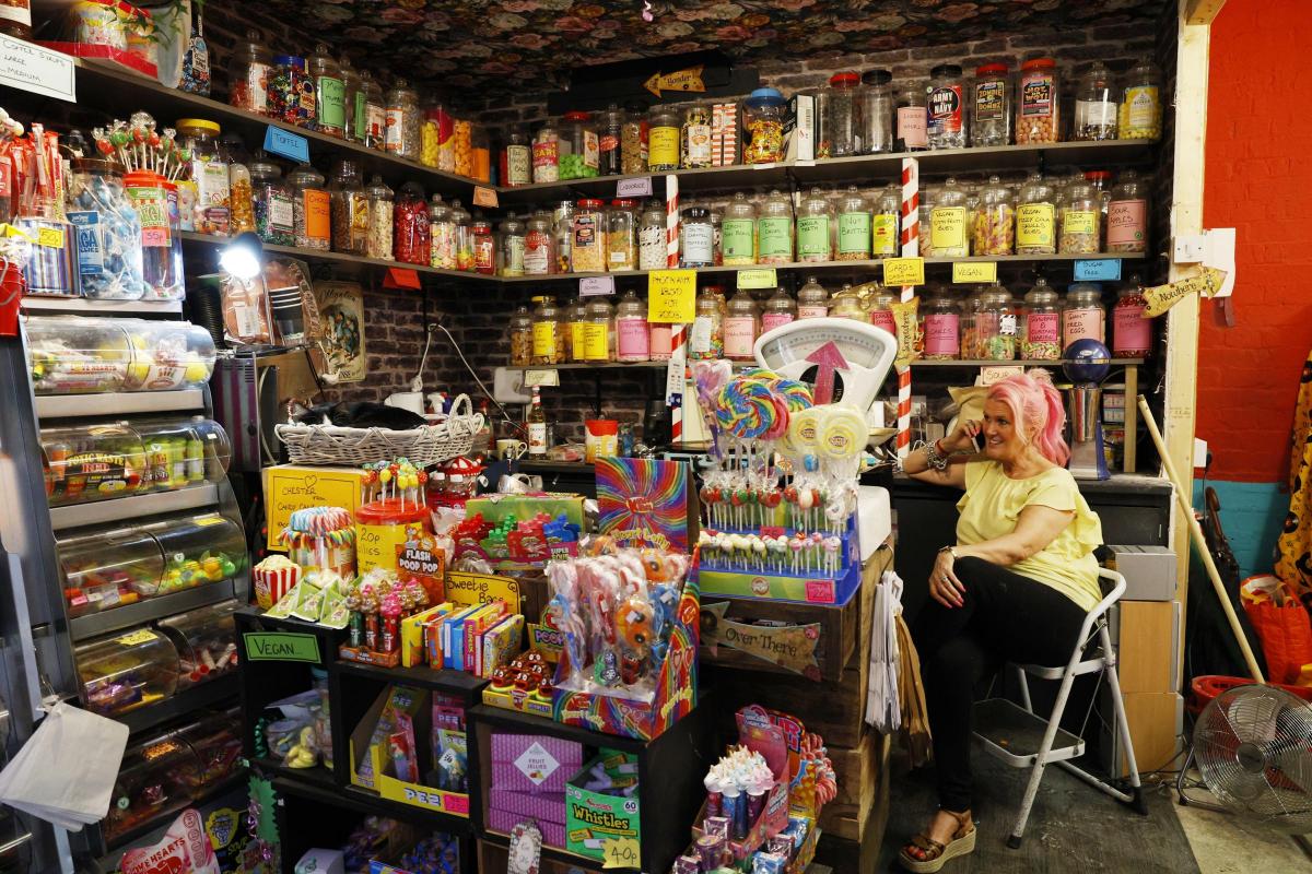 A woman sits in a sweet shop in Tooting market in London, Britain 19 May 2022 (photo: Facundo Arrizabalaga/MyLondon)