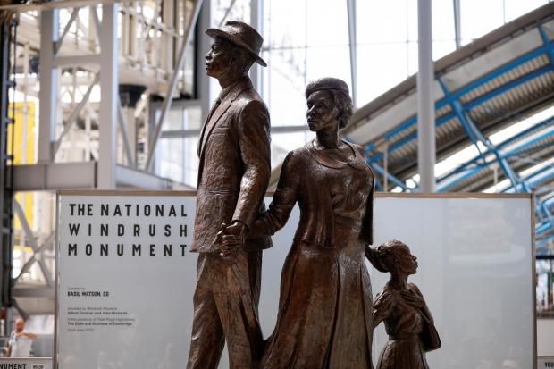 Wandsworth Times: The National Windrush Monument at Waterloo Station. The statue - of a man, woman and child in their Sunday best standing on top of suitcases - was designed by the Jamaican artist and sculptor Basil Watson