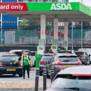 A member of staff directs drivers queuing for fuel at an Asda petrol station in south London